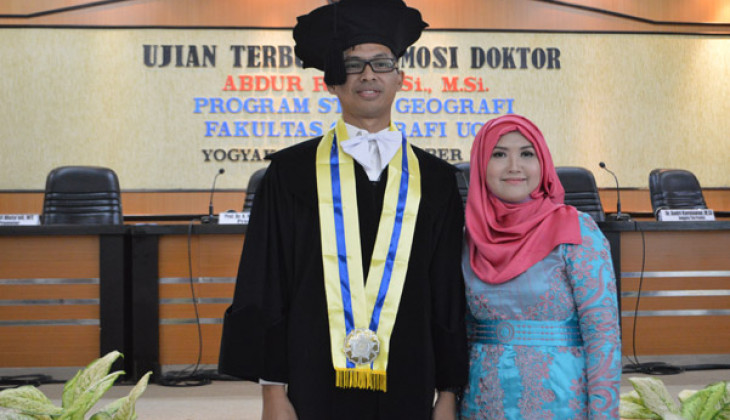 Abdur Rofi bersama isteri seusai melaksanakan ujian terbuka program doktor, Selasa (22/12) di Auditorium Merapi Fakultas Geografi UGM.