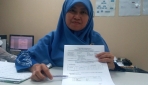 Ahli Mikrobiologi Klinis UGM, dr. Titi Nuryastuti, M.Si., Ph.D., Sp.MK., menunjukkan contoh hasil pemeriksaan laboratorium TB.