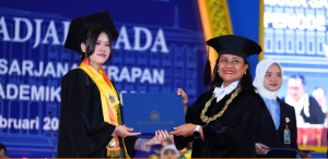 Cynthia Fransisca receiving recognition as the top undergraduate graduate at FEB UGM.