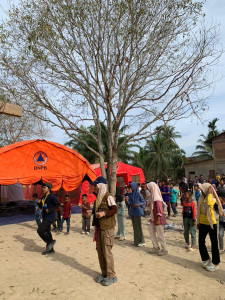 UGM KKN-PPM team distributing aid and supporting temporary shelters in post-disaster recovery.