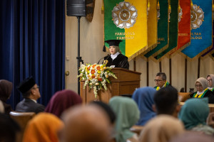 Professor Dwi Endarti delivering an inaugural speech on pharmacoeconomic modeling at UGM