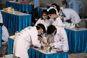 Reactics Antrasena team members prepare their chemical reaction-powered prototype car during the competition.