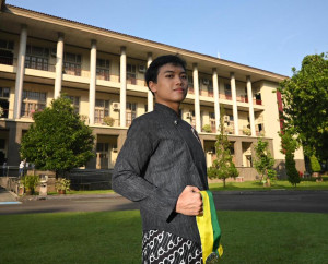 Tegar Rinang Pratama poses in front of Balairung UGM after graduating from UGM