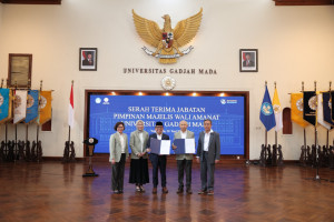 Professor Pratikno hands over leadership of the UGM Board of Trustees to Professor Tumiran during a ceremony at the UGM Senate Hall.