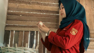 UGM student Anjeli Astriani stands inside a chicken coop at Bejo Farm, her poultry business in Klaten, Central Java.